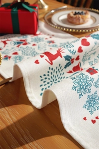 Detail of Christmas table runner with red reindeer and snowflake prints on thick fabric