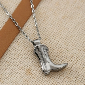 Detailed macro view of vintage cowboy boot pendant with guitar engraving on beige linen