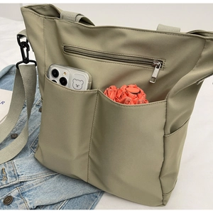 Khaki nylon tote bag detail with dual front pockets and shoulder strap for daily use
