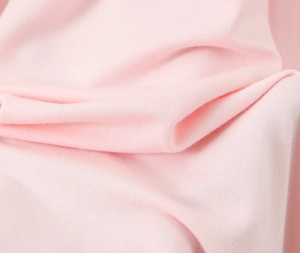 Gros plan sur la texture du tissu en maille rose doux montrant les détails du tissage