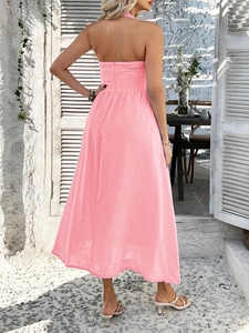 Detail of pink halter backless maxi dress showing texture and fit on sunlit terrace