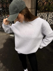 Detail of light gray fleece sweatshirt fabric texture and olive green baseball cap