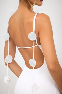Détail d'une robe de soirée blanche avec dos nu et décorations florales en 3D