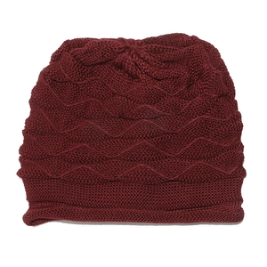 Detailed close-up of dark red knitted beanie featuring a textured wave pattern and folded cuff