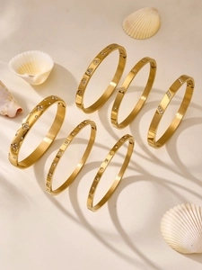 Detailed view of six gold-plated geometric bangles with star and heart zircon carvings