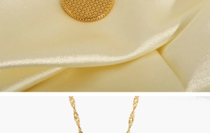 Close-up of gold starburst pendant on silk fabric with elegant water wave chain