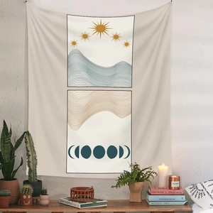 Detail of bohemian wall tapestry featuring sun and moon phases over abstract mountains