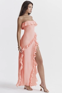 Détail d'une robe rose corail épaules dénudées avec volants et fente latérale haute