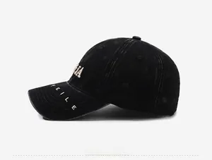 Detail view of washed black cotton baseball cap with embroidered lettering and vintage texture