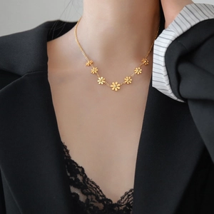 18K gold plated titanium steel daisy necklace featuring seven delicate floral pendants