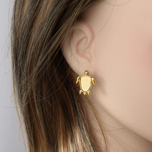Minimalist gold stainless steel sea turtle stud earring shown on a model's ear