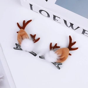 Close-up of brown reindeer antler hair clips with white plush balls and metal duckbill clips
