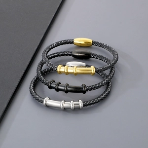 Three braided black leather bracelets with magnetic clasps in gold black and silver steel
