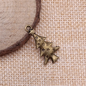 Antique bronze Christmas tree metal pendant with star pattern on burlap background