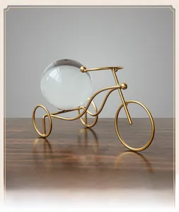 Close-up of golden metal tricycle ornament featuring a large clear crystal ball sphere