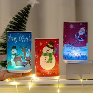 Three Christmas LED pillar lights featuring Santa and snowman patterns in a warm home setting