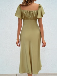 Détail d'une robe élégante en satin vert olive avec dos nu et fente sophistiquée