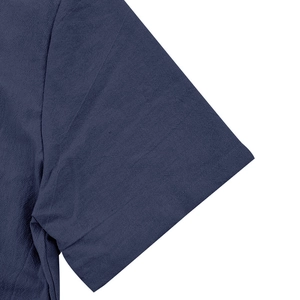 Close-up of the textured linen cotton fabric and neat stitching on dark blue shirt sleeve