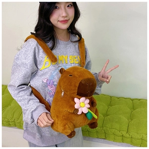 Brown capybara plush backpack with a pink flower detail worn by a model in casual setting
