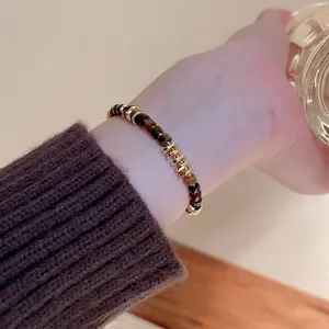 Tiger eye stone beaded bracelet with irregular gold spacers worn on woman wrist