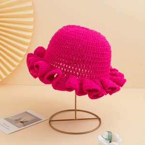 Handmade rose red knit crochet bucket hat with elegant ruffled brim on a metal stand