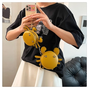 Detailed view of yellow crab leather purses with metal chains and cute doll styling