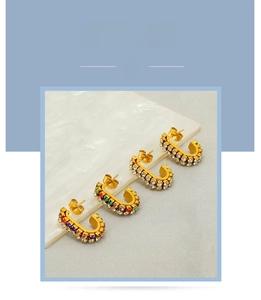 Detailed view of 18k gold-plated C-shaped earrings with colorful and white rhinestones