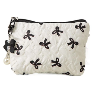 Beige quilted makeup bag with black bow print and pearl bow charm accessory