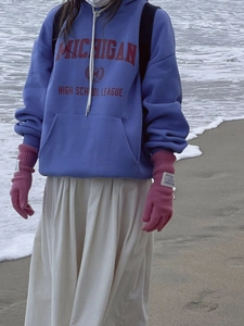 Guantes de punto rosa con función de pantalla táctil usados en una playa
