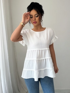 Detail of elegant white short sleeve blouse featuring tiered ruffle design and textured fabric