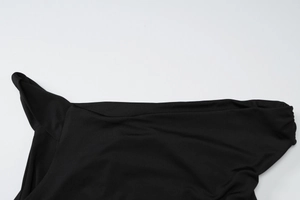 Close-up of black knit fabric showing the detailed neckline stitching and ribbed texture