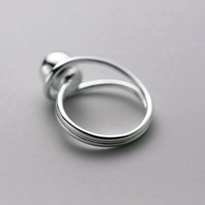 Detailed close-up of a silver minimalist double-band ring with a polished sphere centerpiece