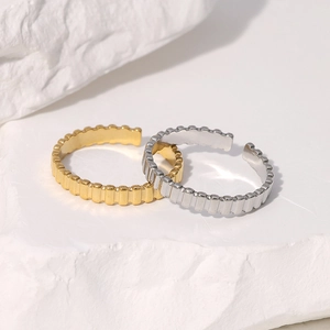 Detail of adjustable gold and silver stainless steel rings with vertical ribbed texture