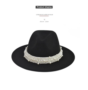 Detalle de sombrero fedora negro de ala ancha con elegantes filas de perlas blancas