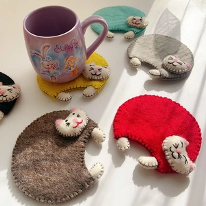 Detailed view of handmade wool felt cat coasters with heat resistant thick texture