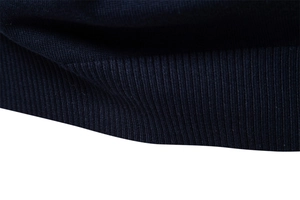 Vue macro de la maille côtelée bleu marine et détails de finition des poignets du pull-over
