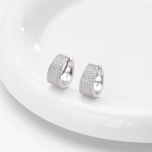 Close-up of 925 sterling silver hoop earrings with micro-set cubic zirconia on white tray