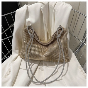 Macro detail of luxury gold rhinestone tote bag with a fine silver chain strap