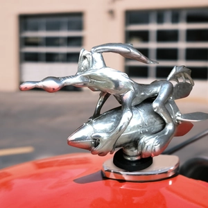 Polished silver metal Wile E. Coyote car hood ornament riding rocket on vehicle hood