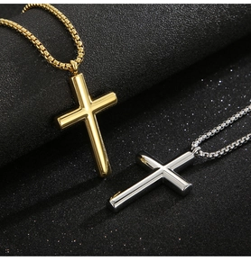 Macro shot showing gold and silver polished stainless steel cross pendants on a dark surface