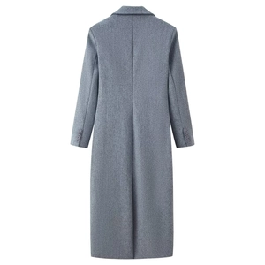 Detail view of the back of a grey wool coat showing back slit and buttoned cuffs