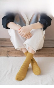 Detail of mustard yellow ribbed cotton socks showing soft velvet fabric texture