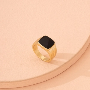 Elegant gold ring with square black gemstone on minimalist pink circular pedestals