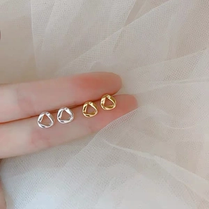 Detailed view of minimalist twisted triangle earrings in gold and silver finish