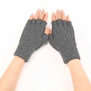 Close-up of grey cable knit fingerless gloves on model with detailed texture on white background