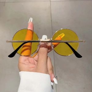Détail de lunettes de soleil rondes vintage avec verres jaunes et monture en métal doré