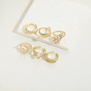 Luxurious 6-piece gold ring set with pearls and zircons on a white stone tray