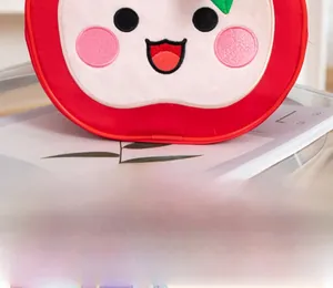 Close-up of a cute red apple plush bag with detailed facial embroidery and soft texture