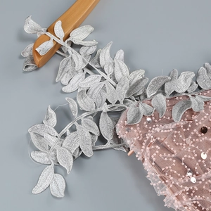 Macro detail of silver leaf embroidery and pink sequins on an elegant evening gown
