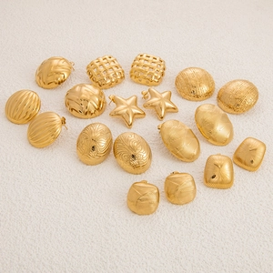 Macro view of vintage gold stainless steel earrings with star and textured relief designs